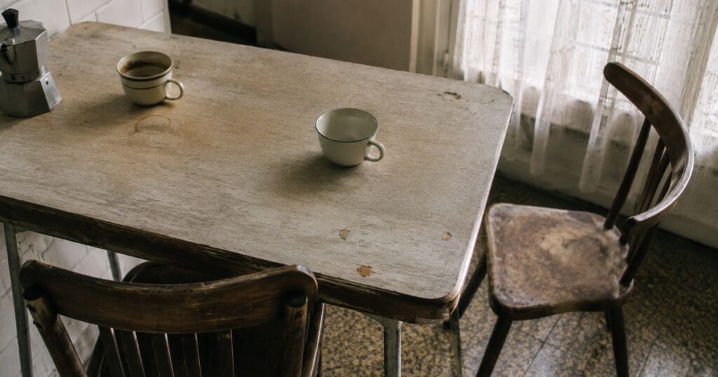 Mesa de cocina con dos tazas, una de ellas sin usar, en una casa familiar