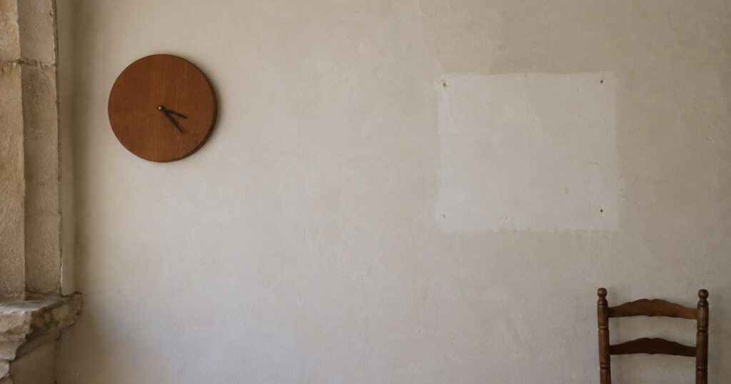 Un reloj de pared parado en una pared vacía
